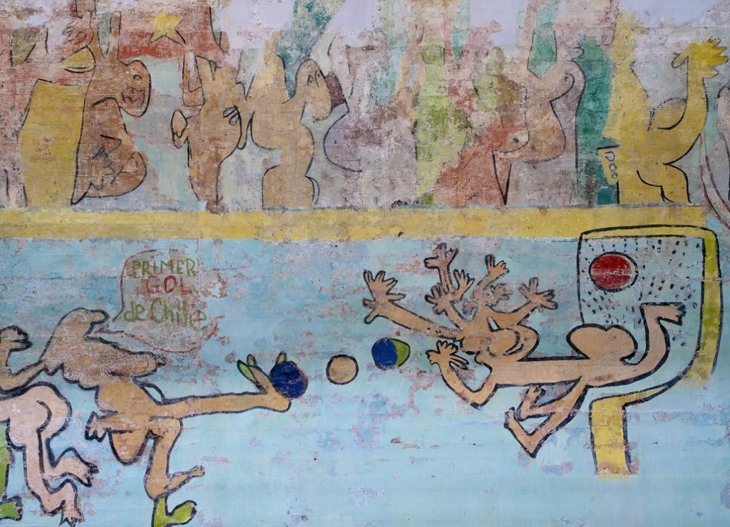 A detail from a mural showing biomorophic figures playing soccer/football. One of the figures says, "primer gol de Chile."